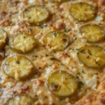 A delicious pickle pie pizza on a wooden board with fresh dill and mozzarella.